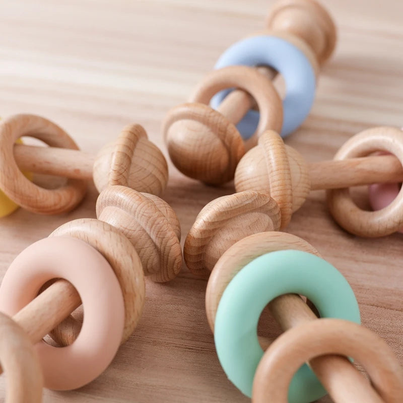 Wooden Baby Rattles with Silicone Rings, showcasing a blend of wood and silicone rings designed for infants to encourage sensory exploration and motor skills development.