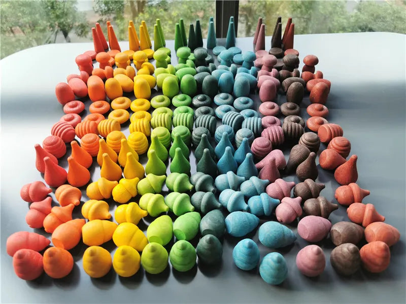 Colorful loose parts wooden oys arranged in a circular pattern on a gray surface.