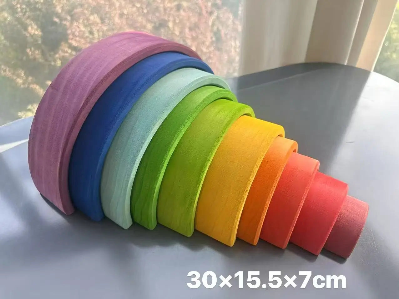 Stack of colorful wooden archs on a flat surface with dimensions displayed.