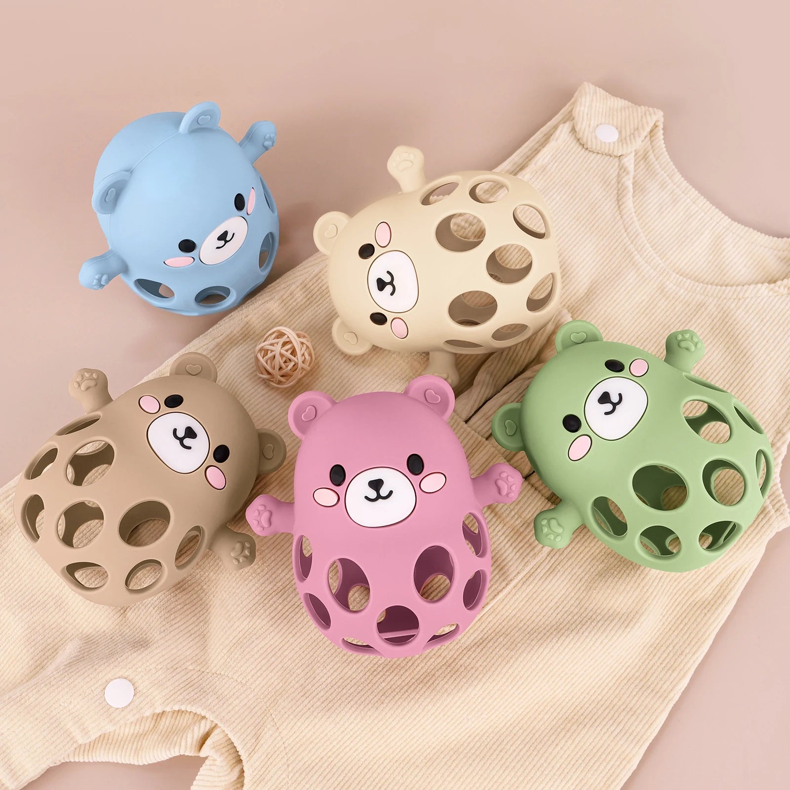 Five colorful bear-shaped bath toys on a beige fabric background