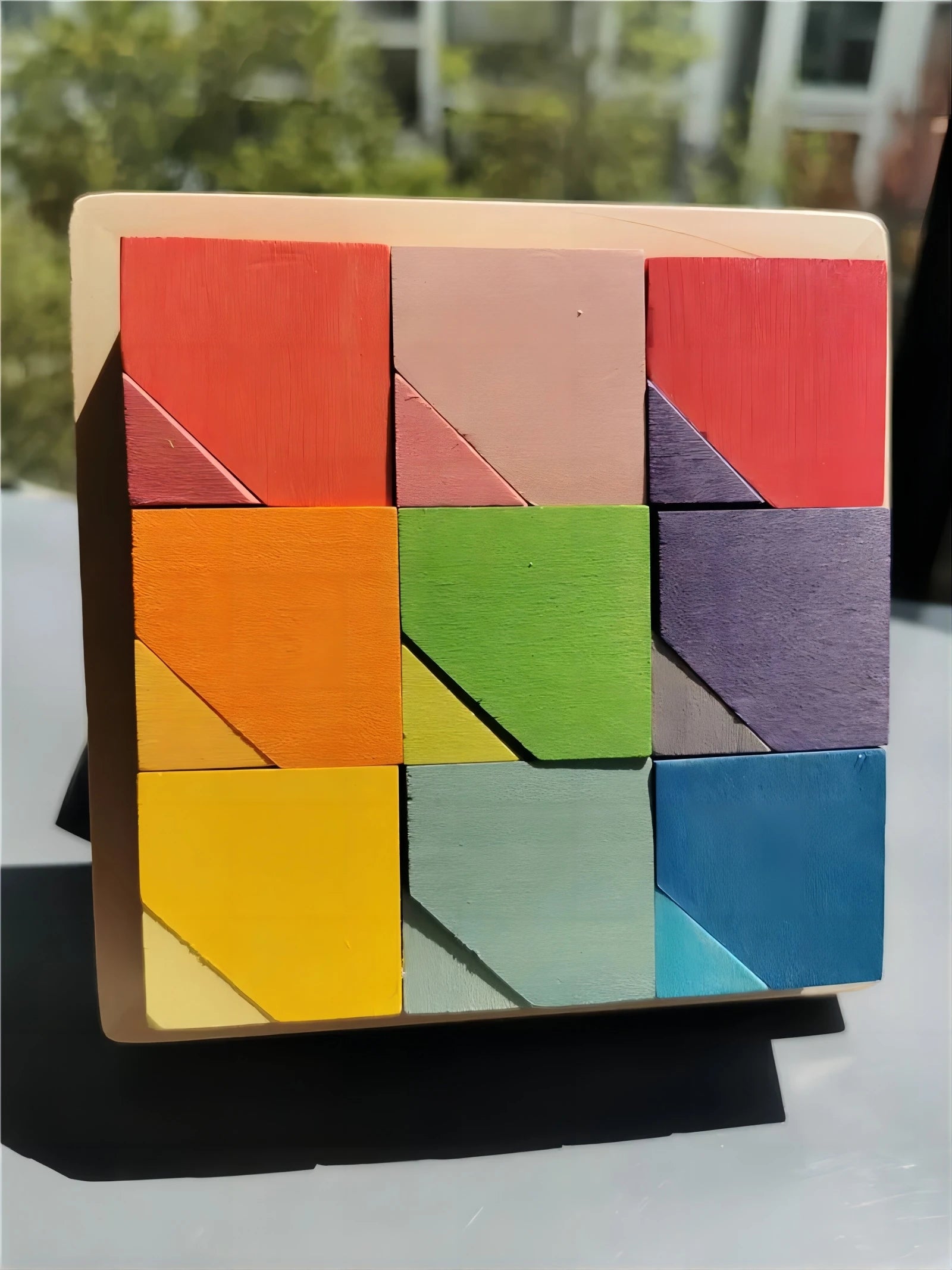 Colorful wooden tangram puzzle on a stand with a blurred background