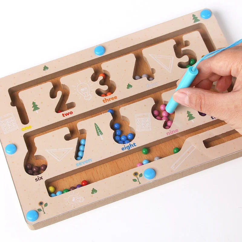 Wooden educational toy with numbers and colorful beads, used by a hand with a blue marker.