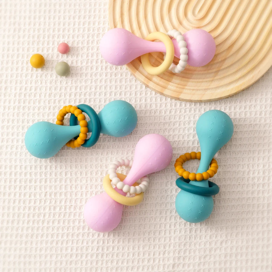 Colorful baby teething toys on a textured surface