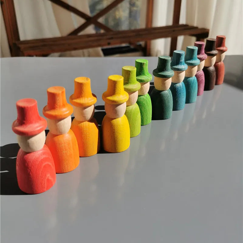 Colorful wooden peg dolls arranged in a row on a reflective surface.