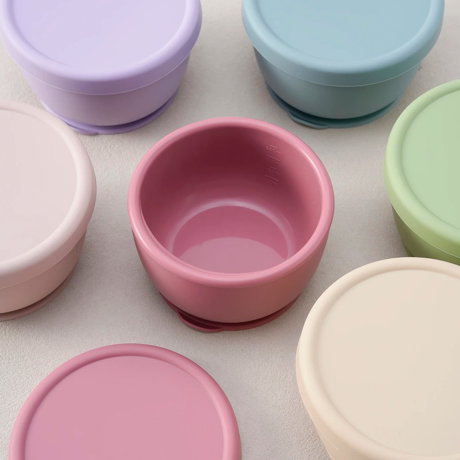 Close-up of a dusty rose silicone bowl with its lid off