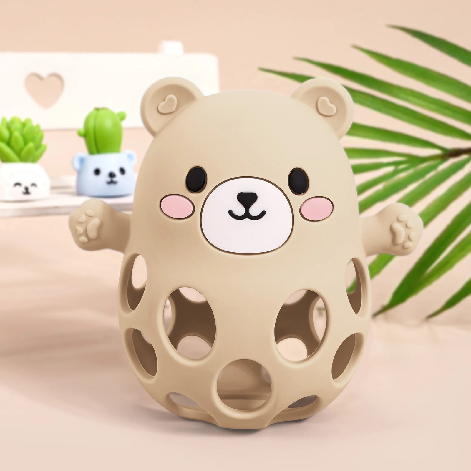 Beige bear-shaped toy with a face on a light pink background