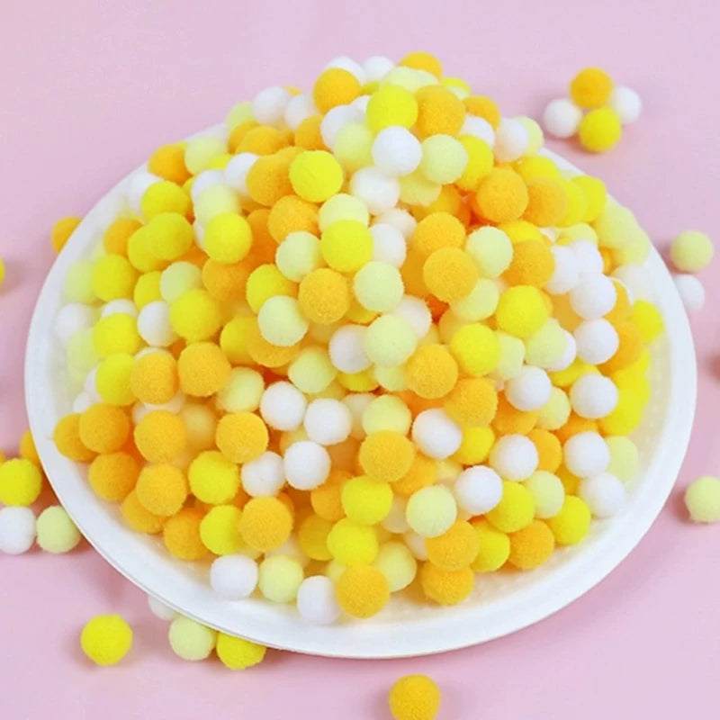 White bowl filled with yellow and white pom-poms on a pink background