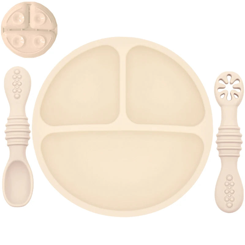 Beige children's dinner set with plate, spoon, and other utensils on a white background