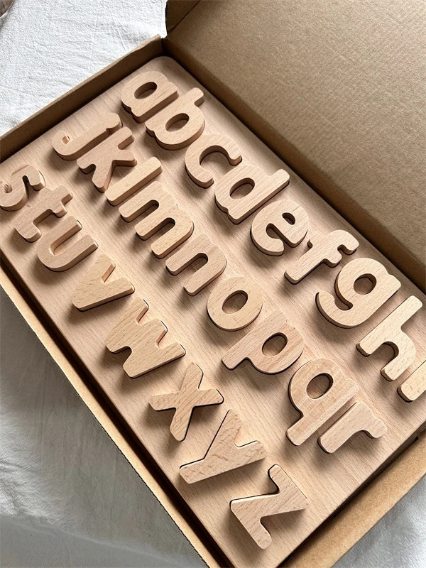 Wooden alphabet letters in a box on a neutral background