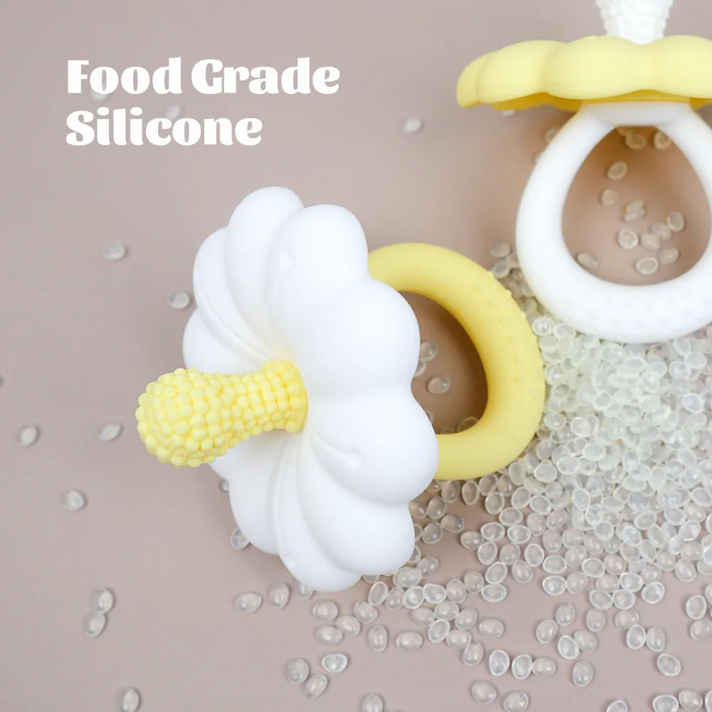 Two silicone teething rings, one white and one yellow, on a beige background with 'Food Grade Silicone' text.