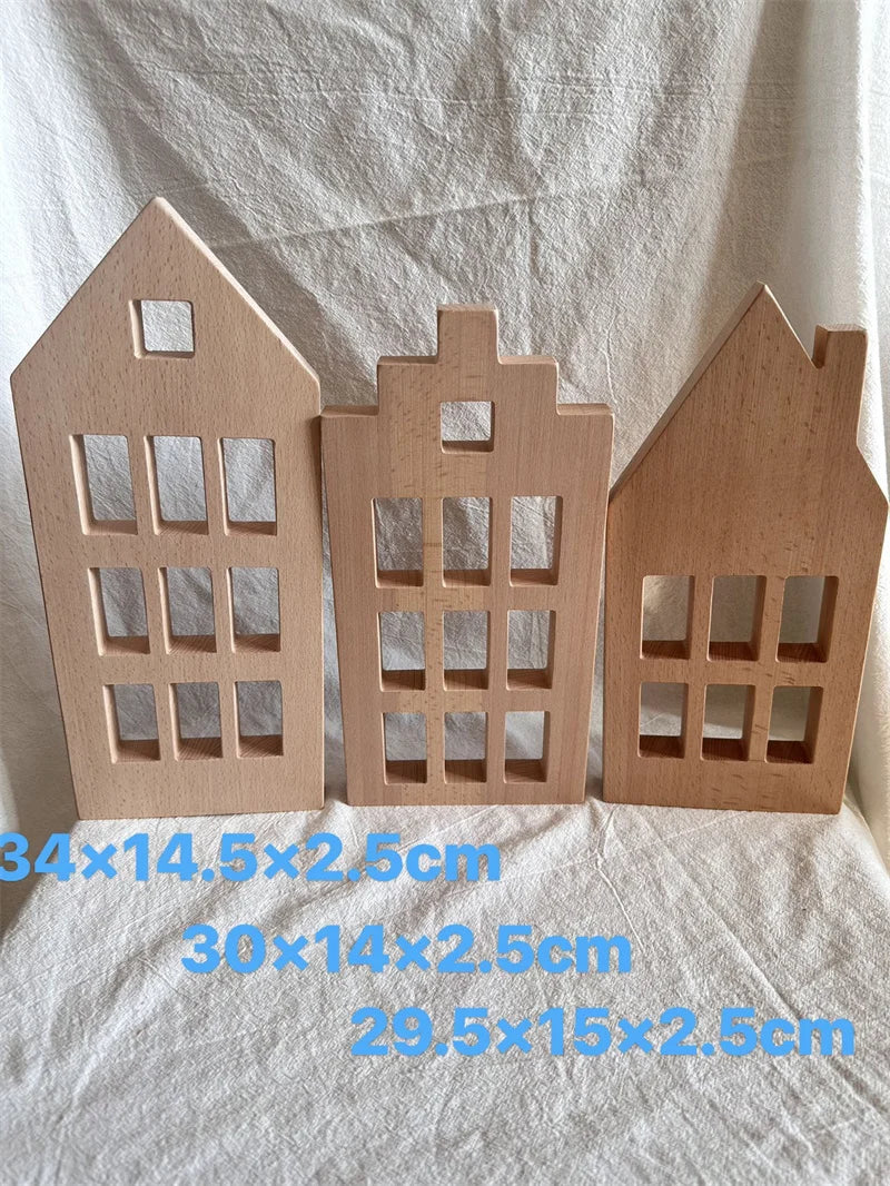 Three wooden house models on a white fabric background with measurements.