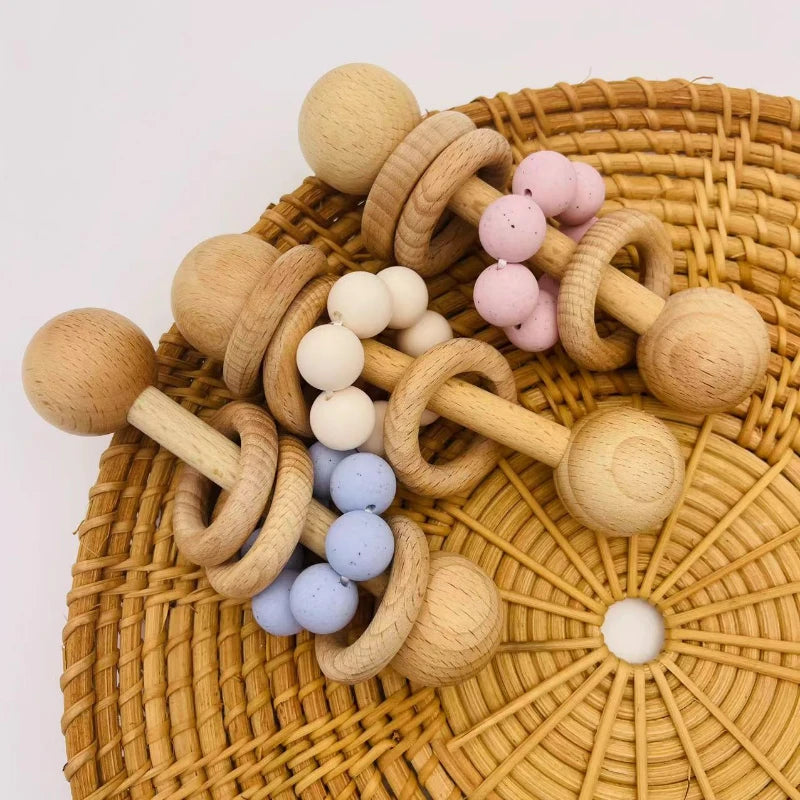 Wooden and silicone baby teething ring on a woven surface