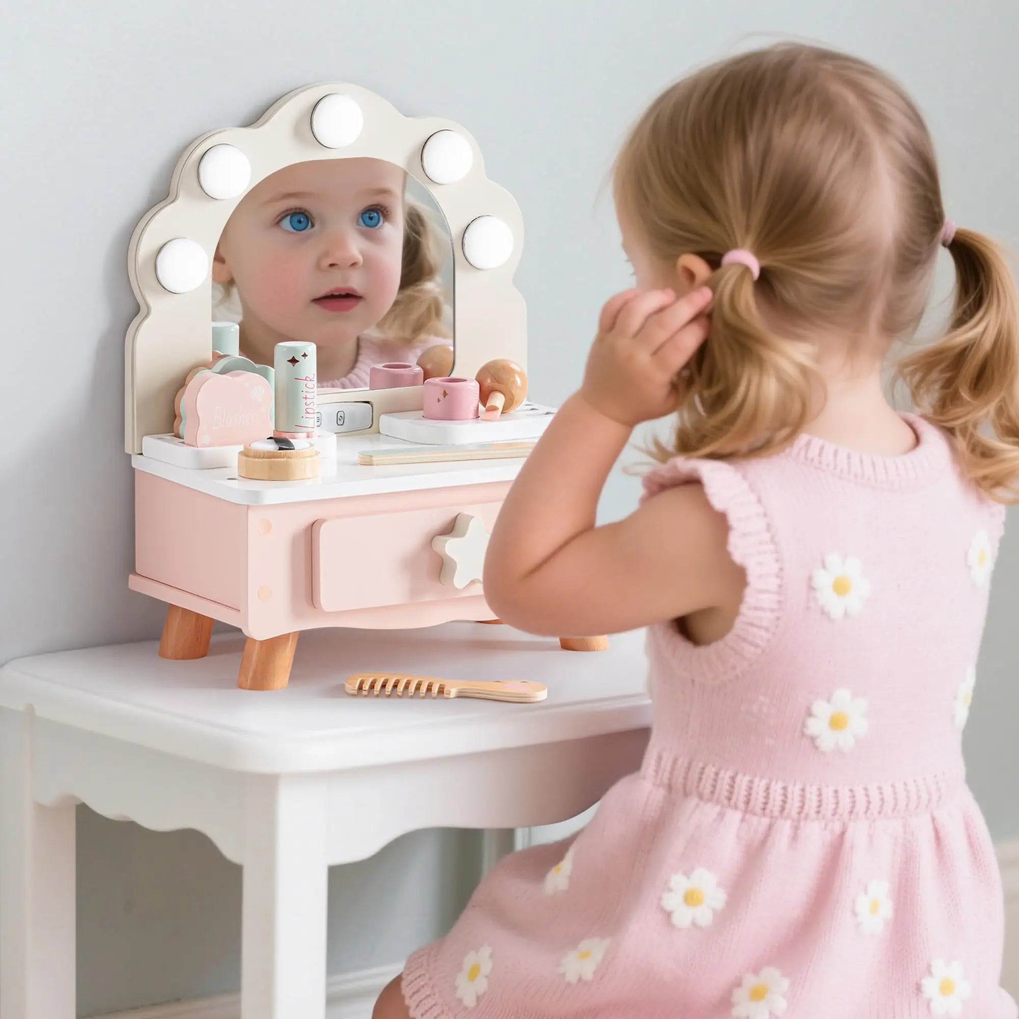 Child playing with a toy vanity set and doll mirror.