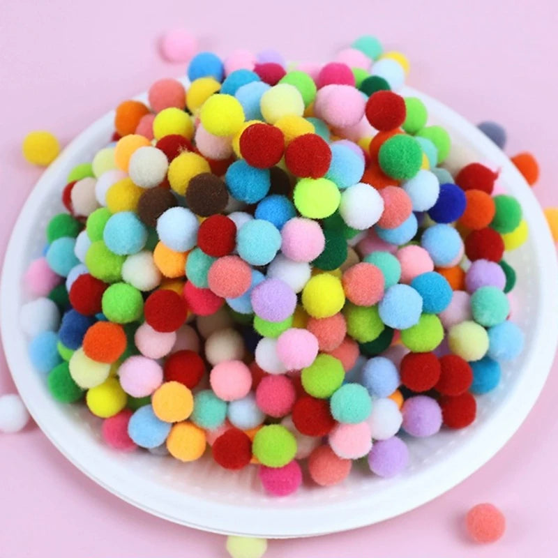 Colorful pom-pom balls on a white plate with a pink background