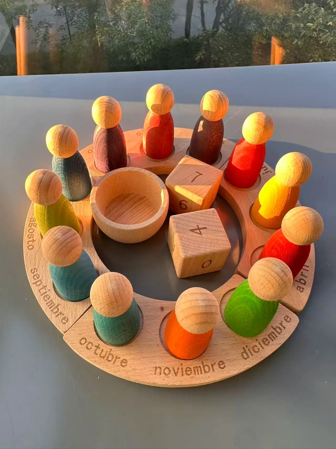 Wooden educational toy with colorful pegs and a circular board with months printed on it.