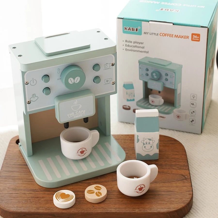 Toy coffee maker set with cups and packaging on a wooden surface