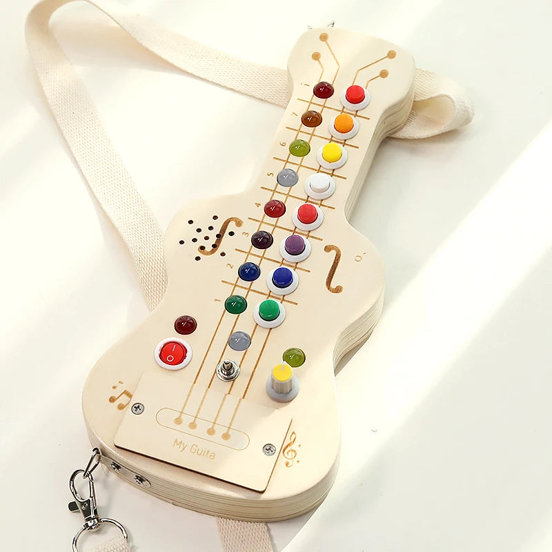 Wooden toy guitar with colorful buttons on a white background