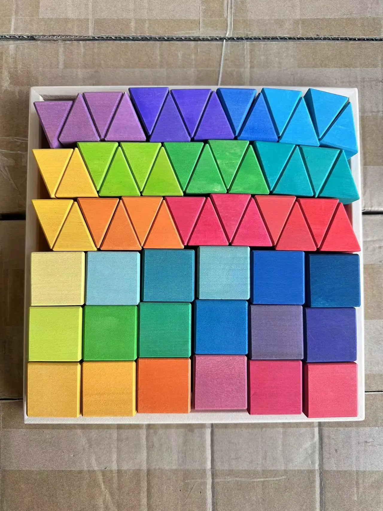 Colorful geometric blocks arranged in a pattern on a wooden surface.