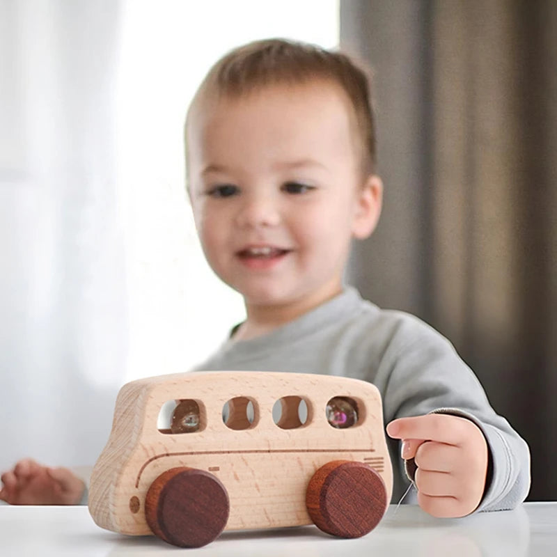 Child playing with Baby Montessori Wooden Cartoon Bus, a wooden toy that promotes imaginative play and motor skill development, from Oliver & Company Montessori Toys.