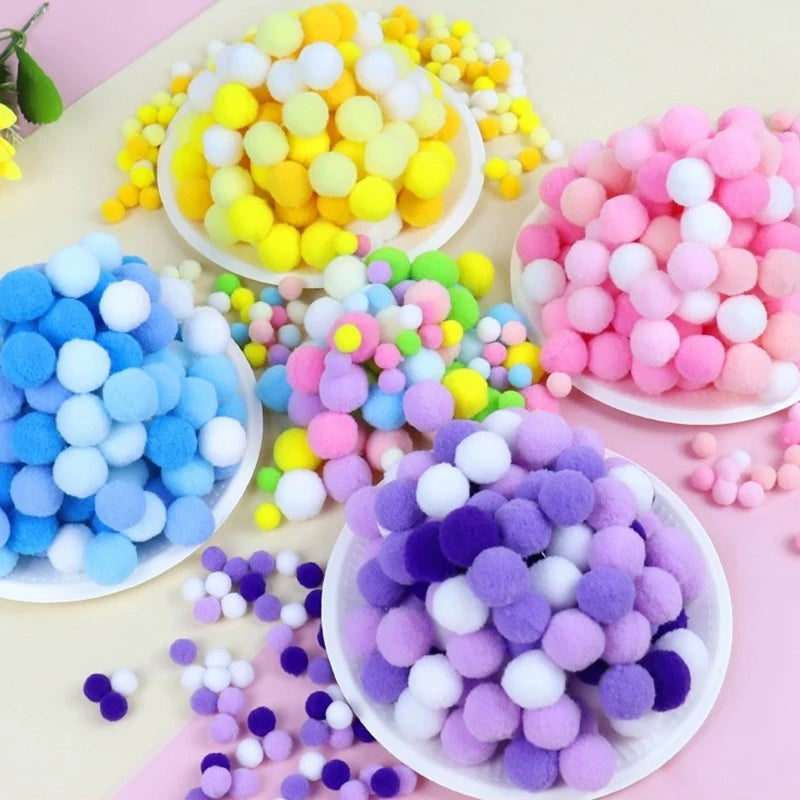 Colorful pom-pom balls on white plates against a pink background