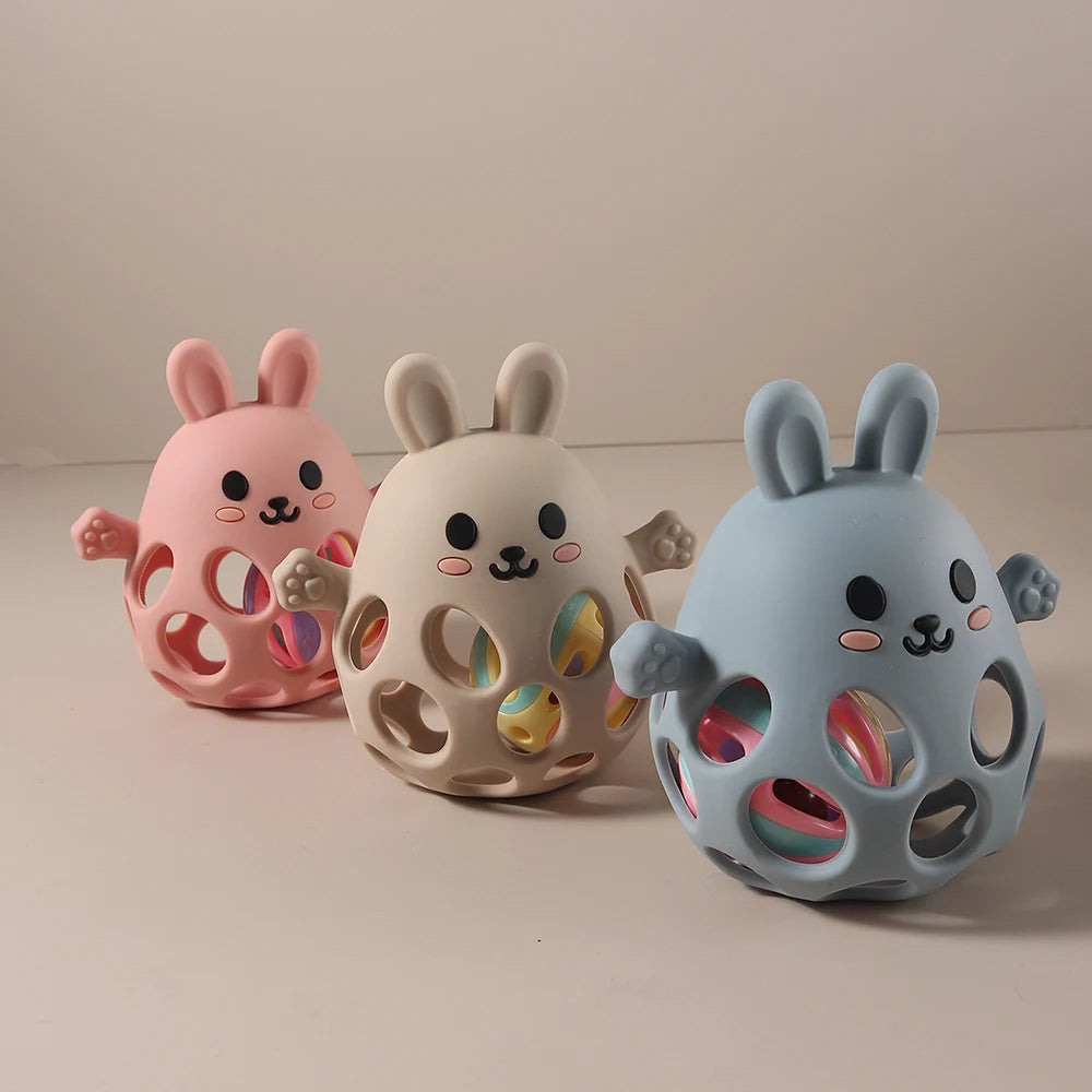 Three colorful rabbit-shaped toys on a beige background