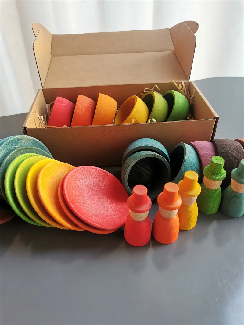 Colorful wooden toys including cups and bottles on a table with an open cardboard box.