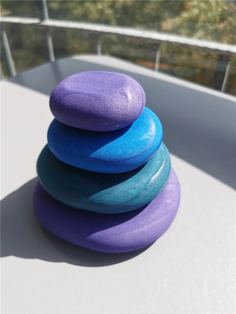 Stack of colorful painted stones on a reflective surface with blurred background