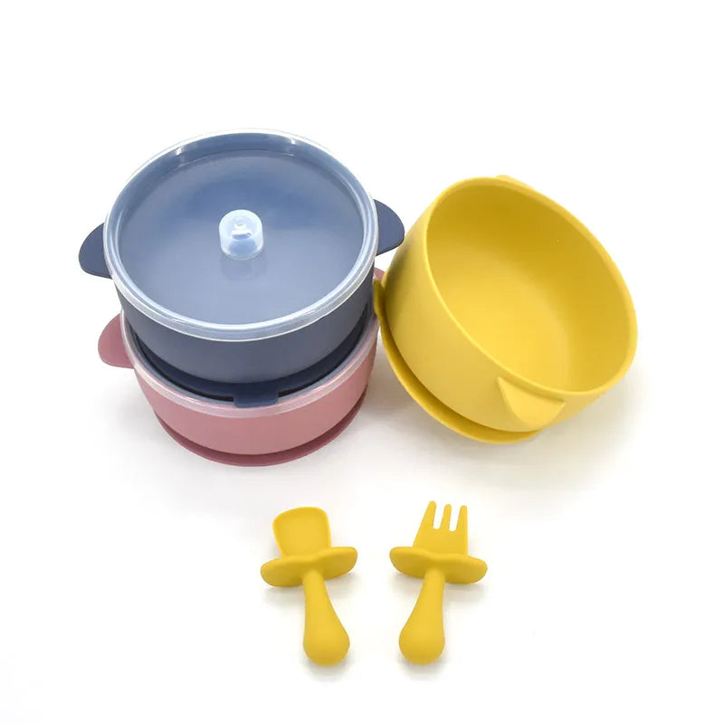 Stacked suction bowls with clear lids beside a mustard bowl