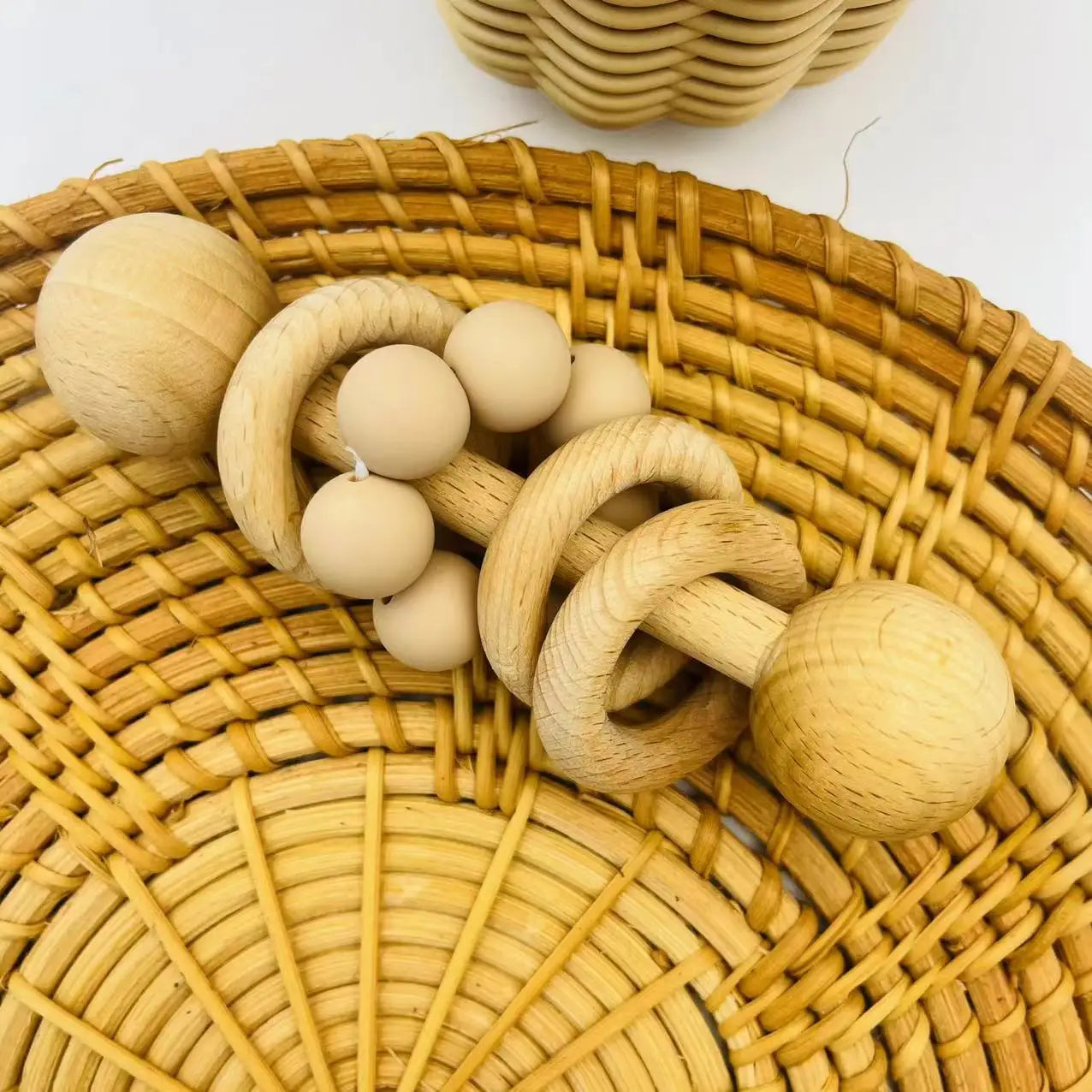Wooden baby teething toys on a woven surface