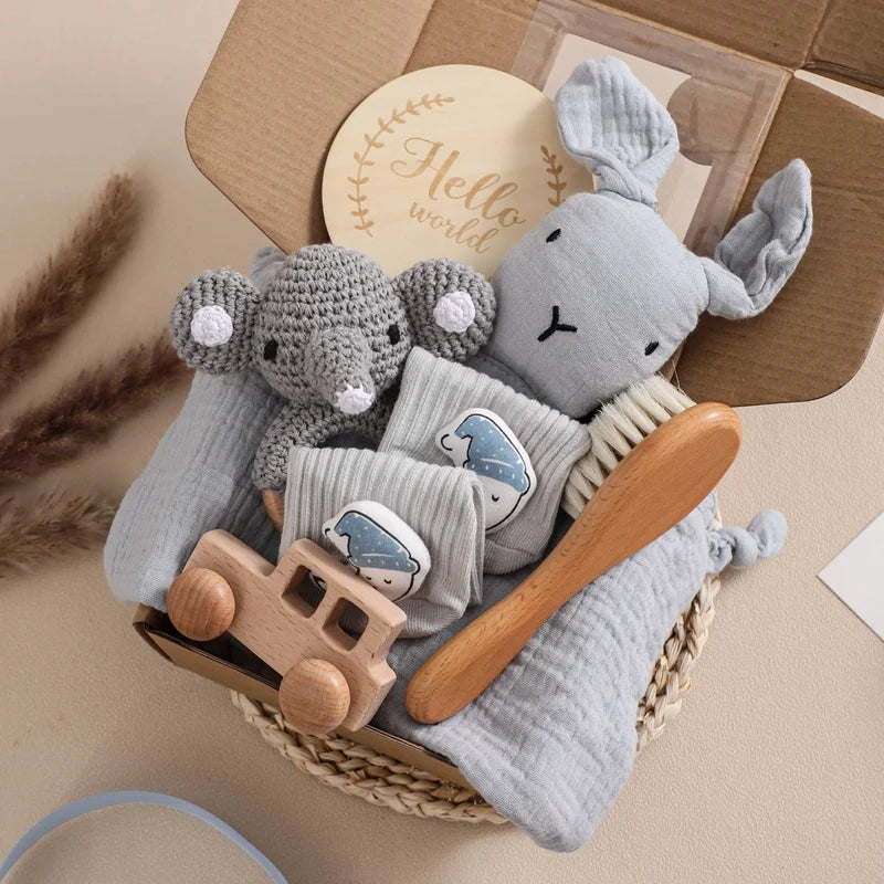 Baby care set with plush toys, wooden comb, and blanket in a basket on a beige background.
