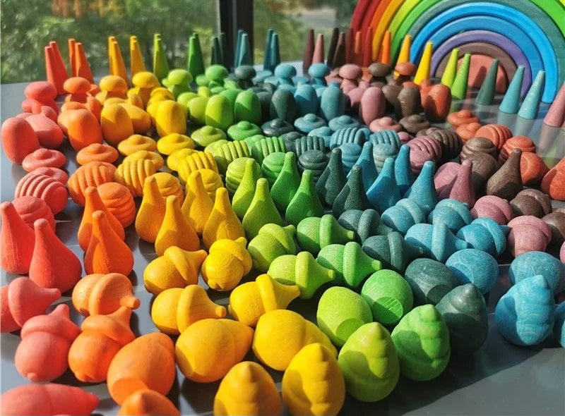 Colorful clay sculptures arranged in a rainbow pattern on a flat surface.