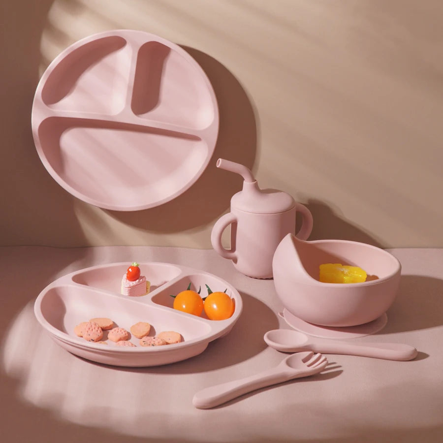 Light pink plate, bowl and straw cup set on a table