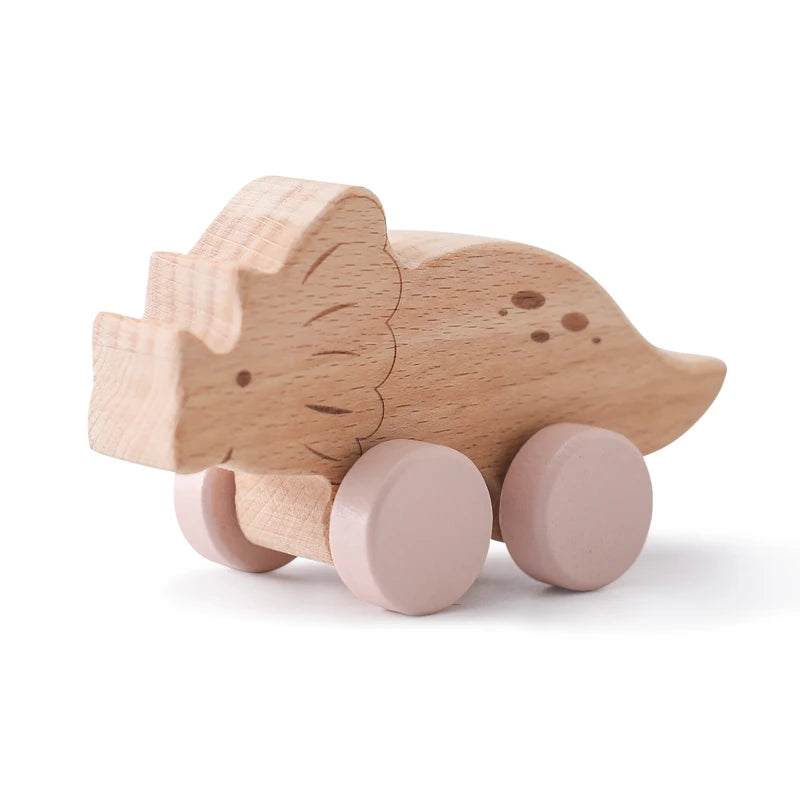 Wooden toy pig with pink wheels on a white background