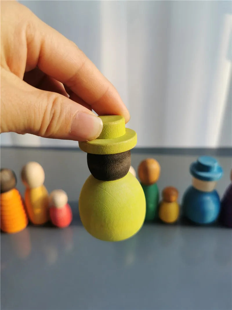 Colorful wooden toys with a hand interacting with one of them on a reflective surface.