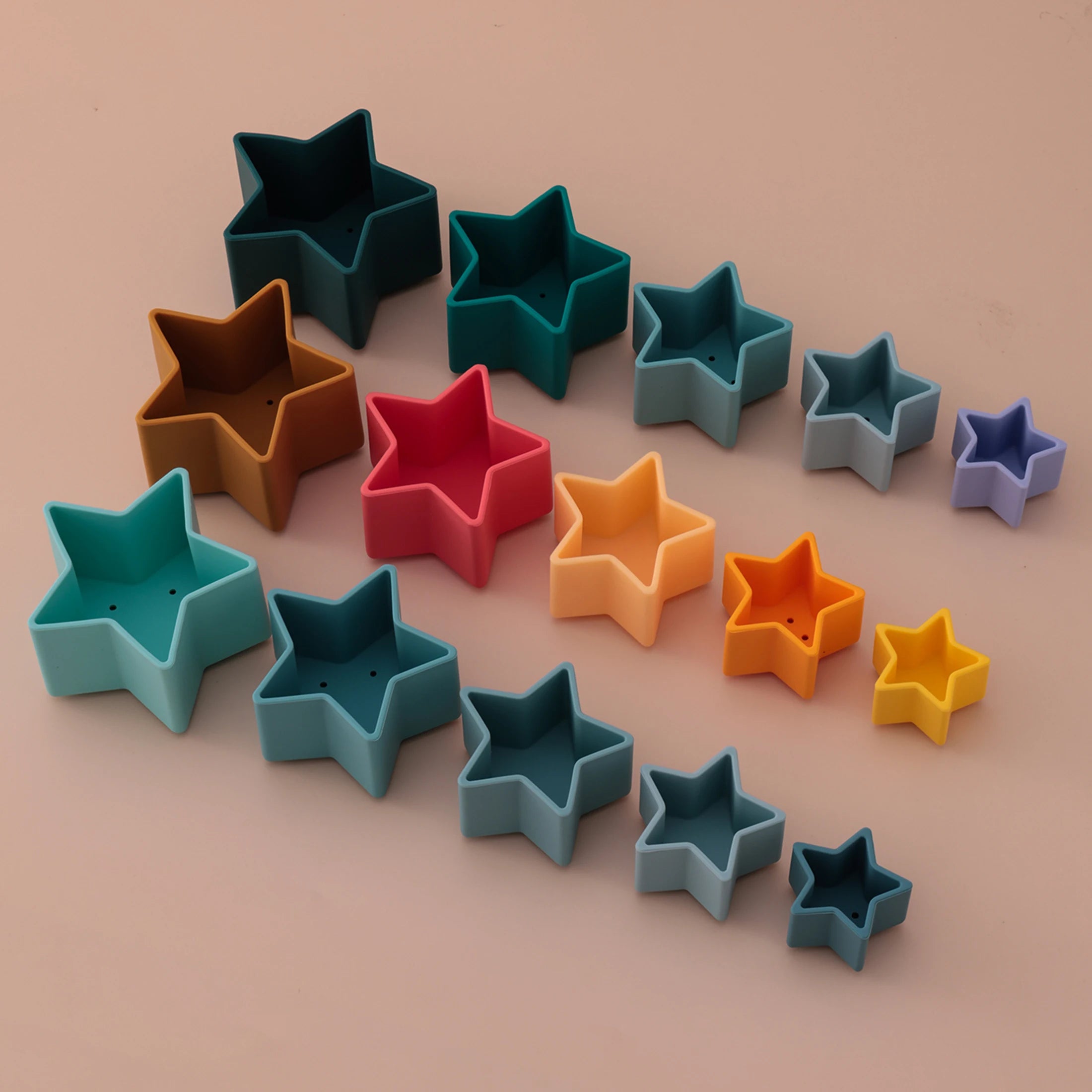 Three sets of silicone star nesting cups laid out by size