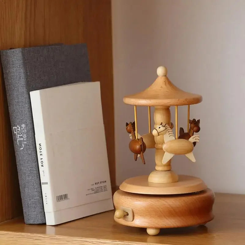 Wooden carousel toy with animals on a wooden shelf next to books | Oliver & Company Montessori Toys