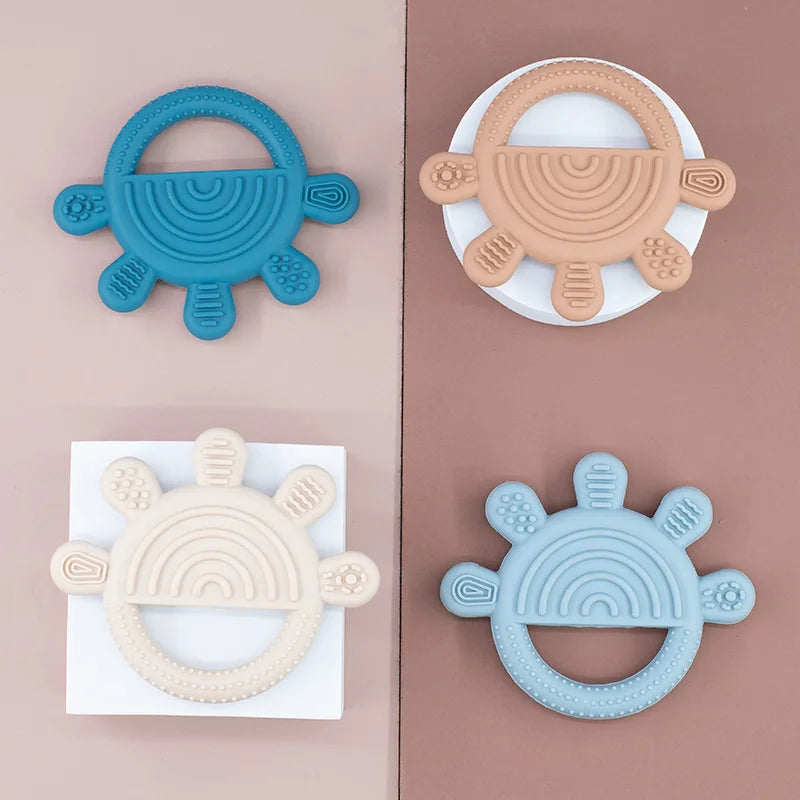 Four rainbow sun teethers in teal, peach, cream and blue