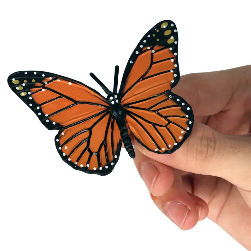 Hand holding a detailed monarch butterfly figure
