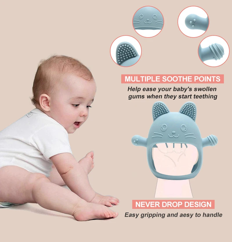 Baby sitting on a beige surface with a blue teething toy featuring cat ears and a smiling face.