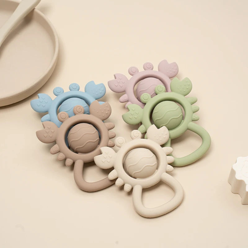 Set of colorful silicone teething rings on a beige background