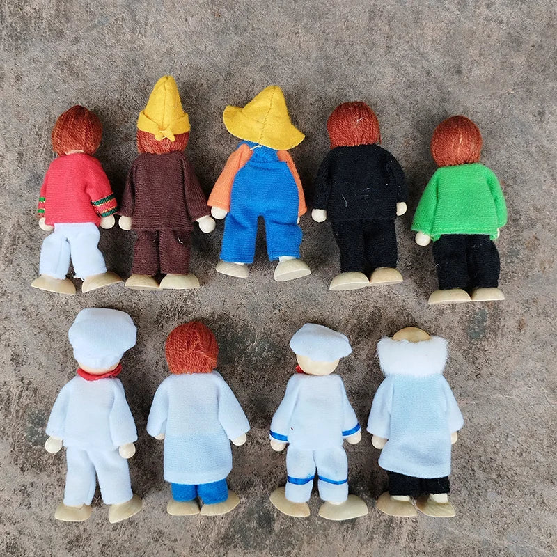 Small figurines of people wearing colorful outfits on a textured surface
