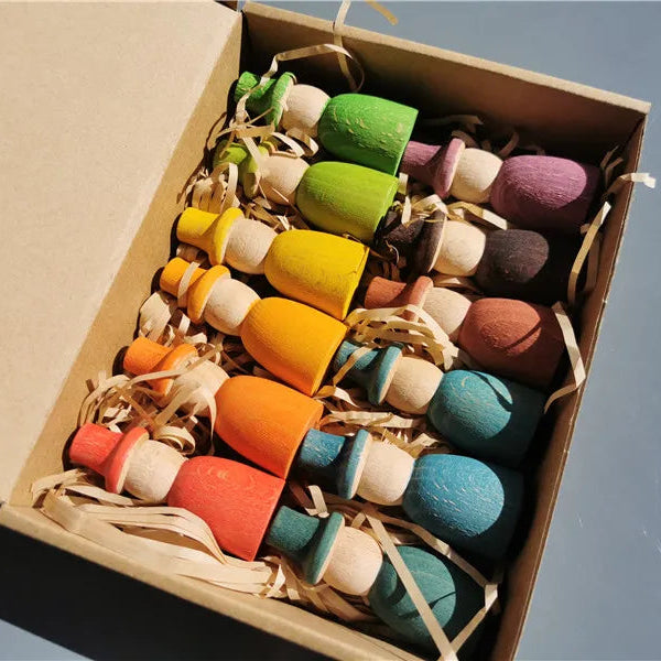 Colorful wooden toys in a cardboard box against a blue background