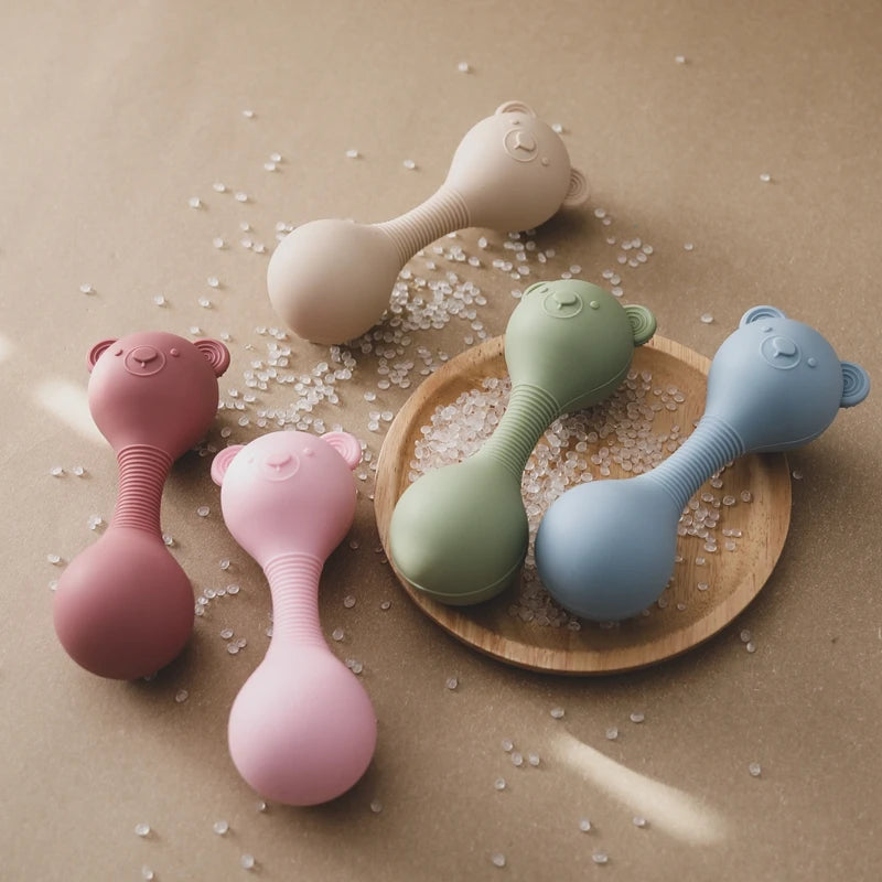 Set of colorful baby rattles on a wooden surface with a neutral background
