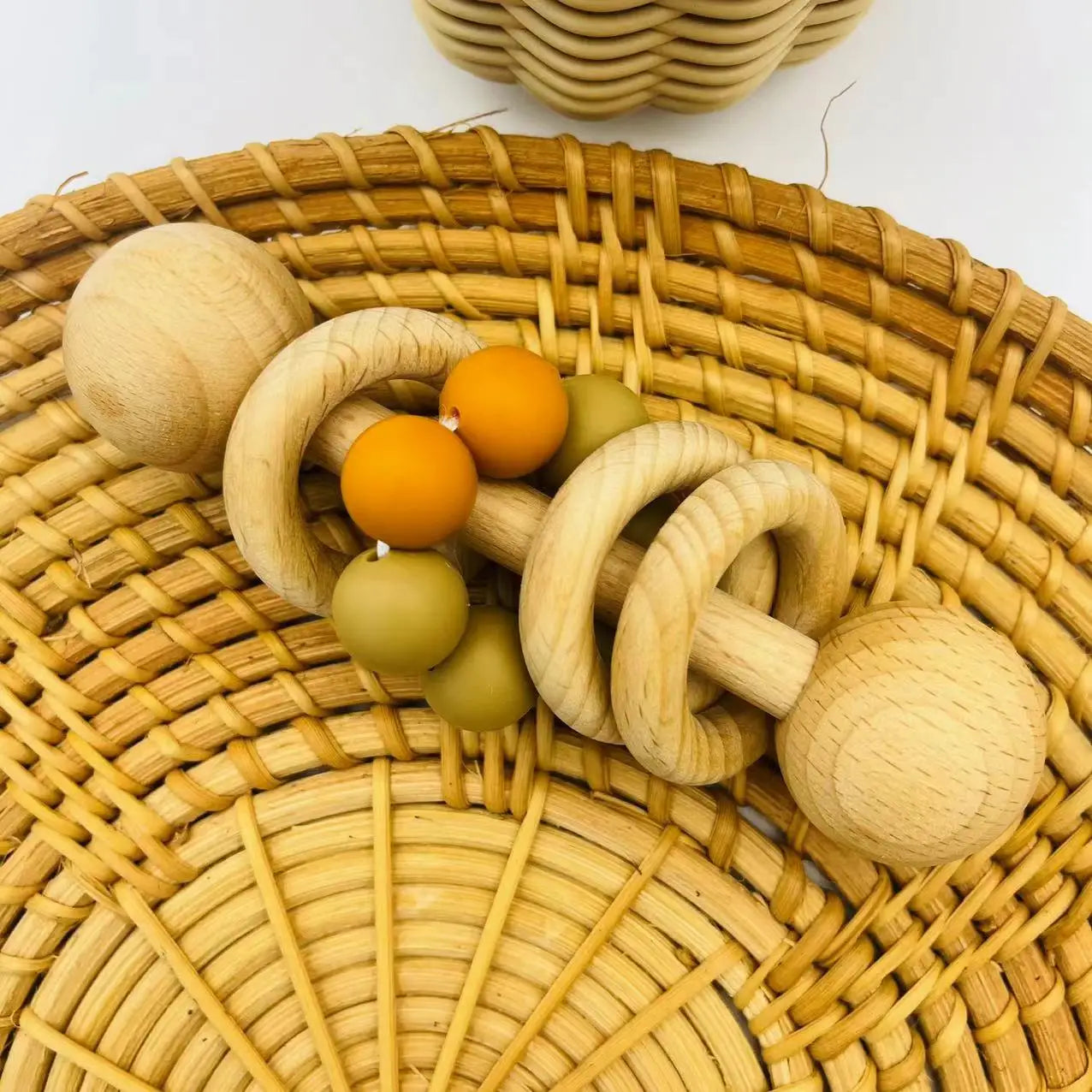 Wooden baby rattle with beads on a woven basket