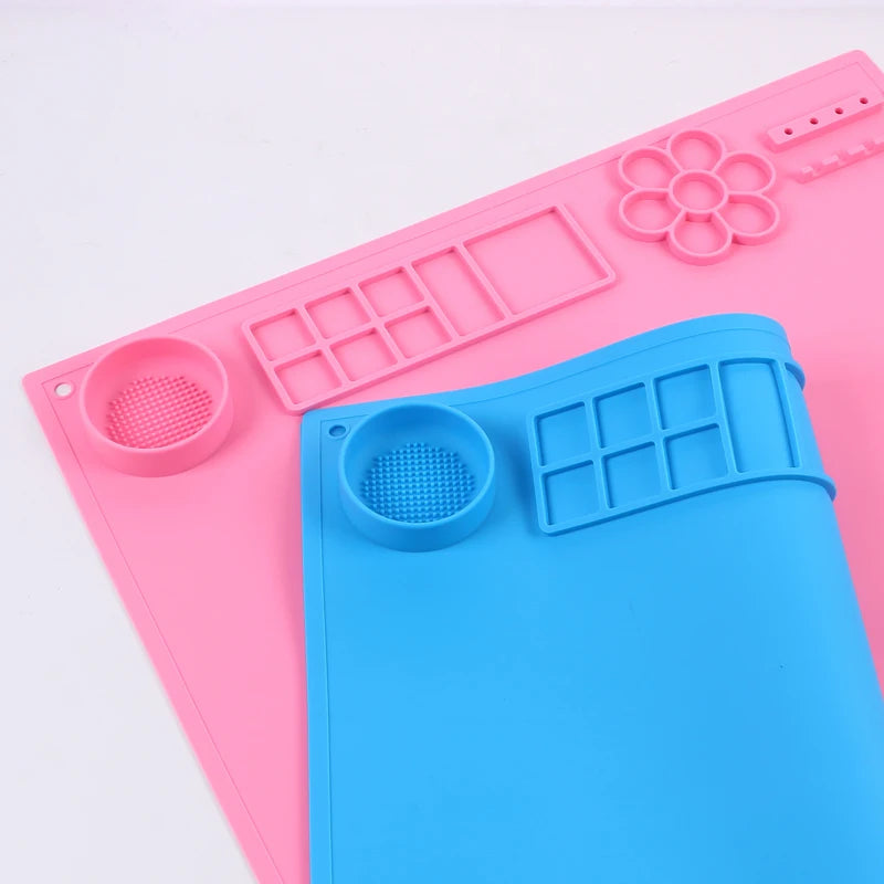 Pink and blue silicone mats with various shapes on a light purple background