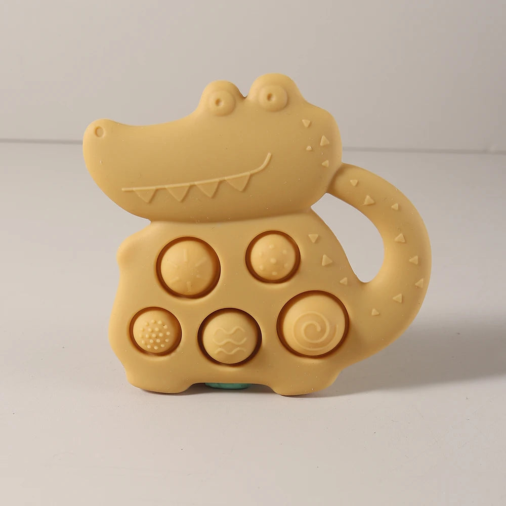 Yellow alligator-shaped toy with textured surface on a light gray background