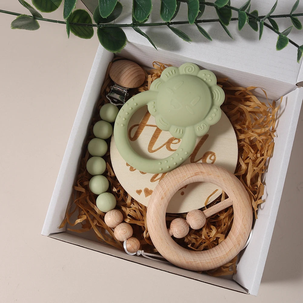 Set of baby toys including a teething ring, rattle, and teether in a decorative box.