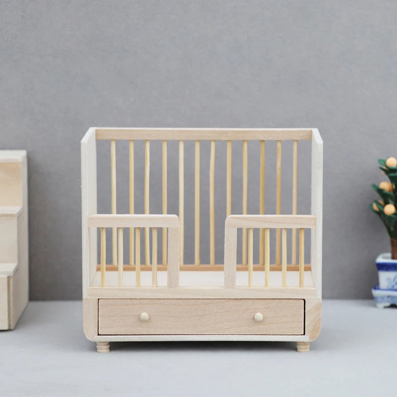 Wooden crib with a drawer against a gray wall