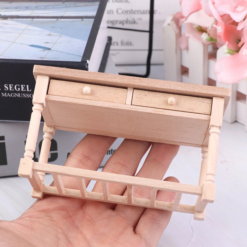 Small wooden desk model with drawers held in a hand, blurred background Oliver & Company Montessori Toys