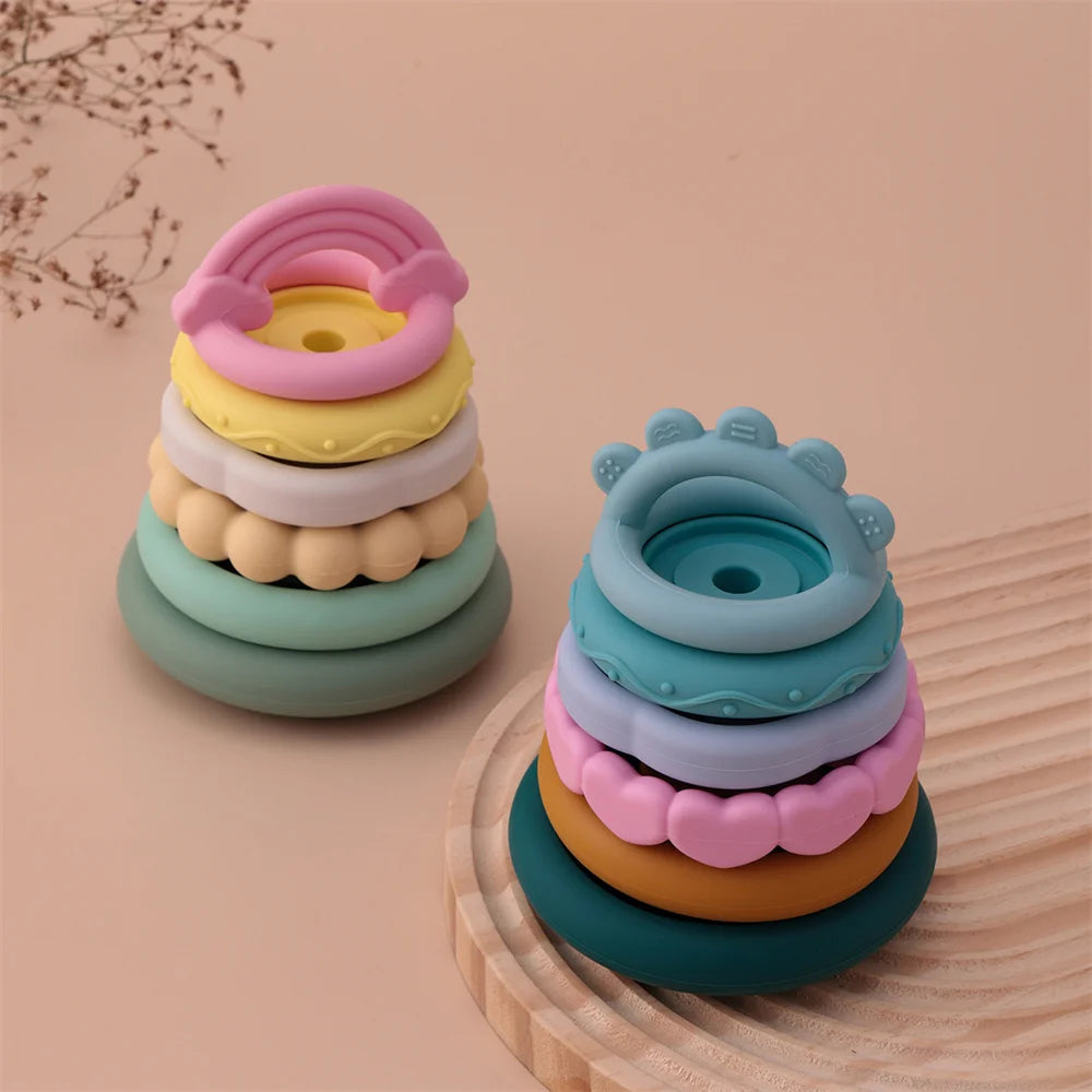 Stack of colorful silicone rings on a wooden surface with a beige background